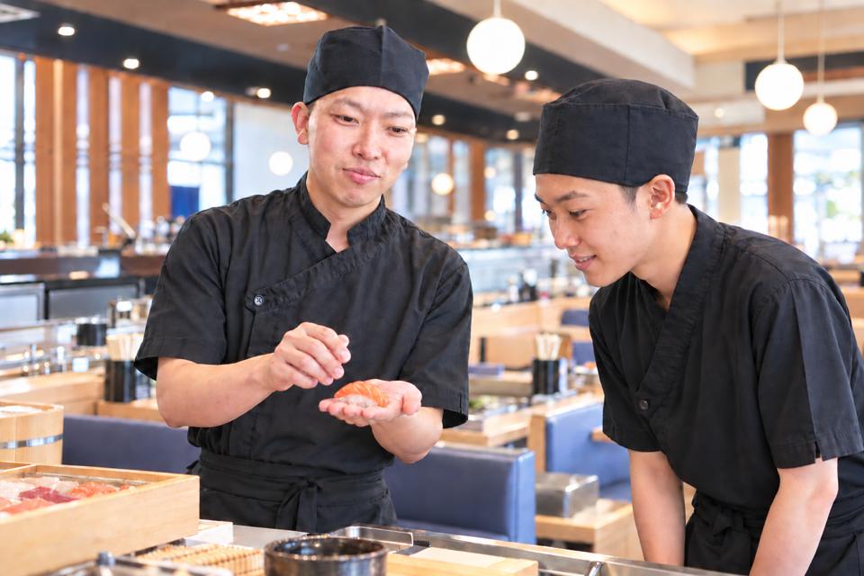先輩が後輩に握りを見せて教えている