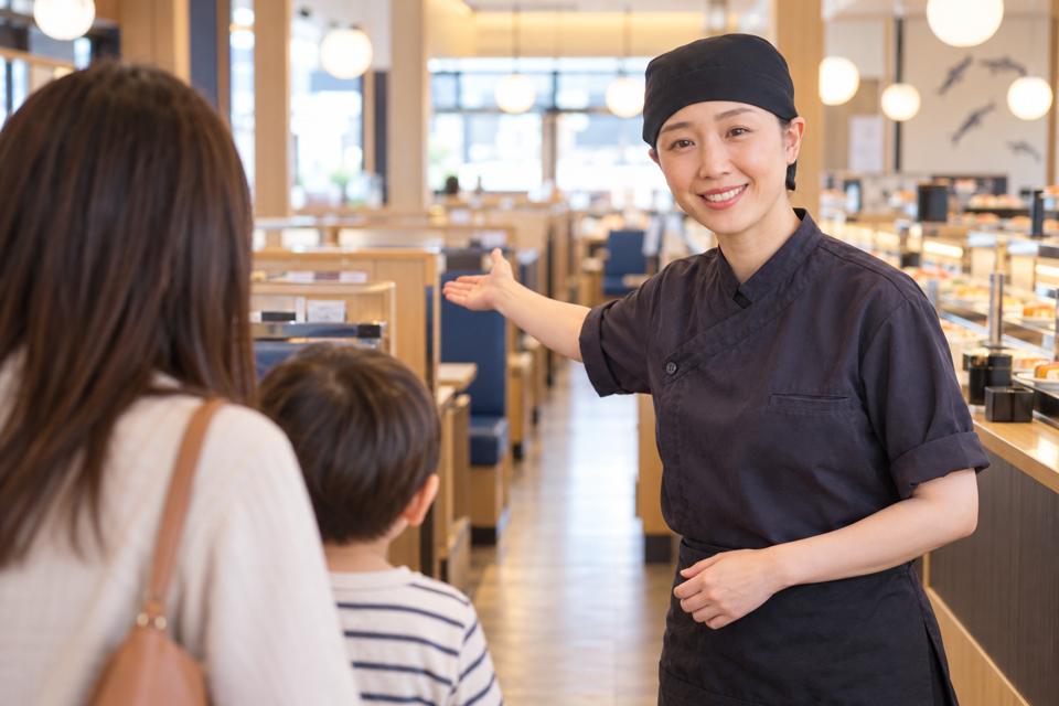 通路からお客様を席へご案内するスタッフ