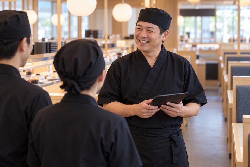 開店前に仲間と打ち合わせをする店長